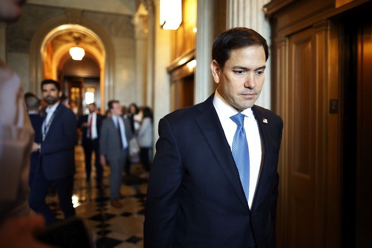 Marco Rubio looks down as he walks through the Capitol
