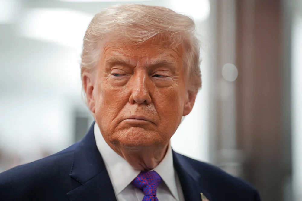 Donald Trump grimaces while looking sideways to his right