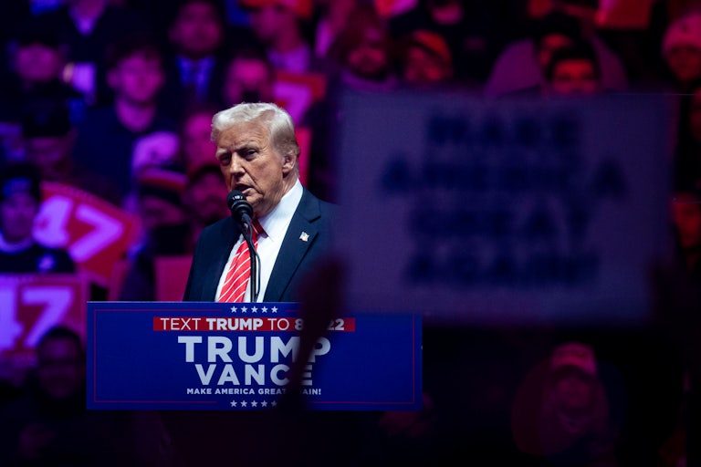 Donald Trump speaks at a podium in Capital One Arena the night before his inauguration