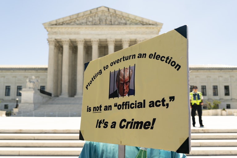 A person holds an anti-Donald Trump protest sign outside the Supreme Court
