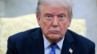 Donald Trump stares blankly ahead while sitting in the Oval Office