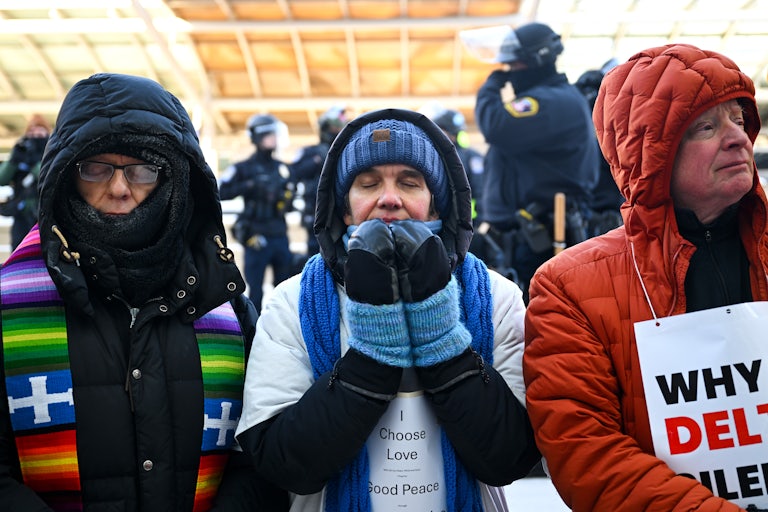 Faith leaders pray during a protest at the Minneapolis airport.