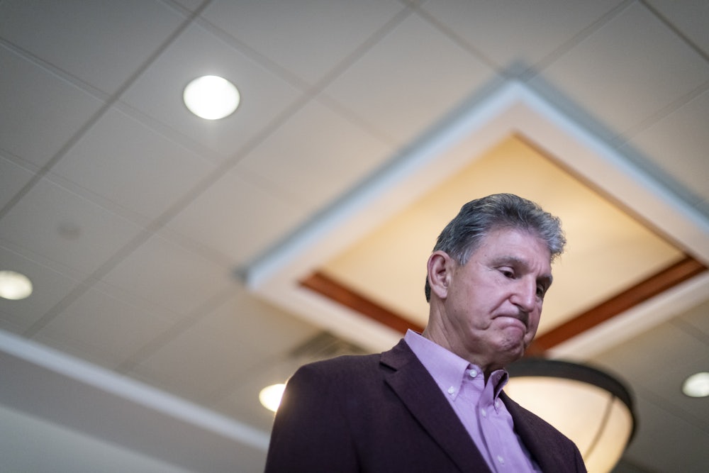 Senator Joe Manchin glances at the ground during a press conference.