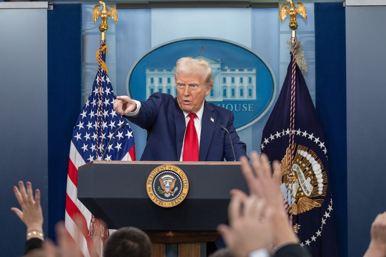Donald Trump points while standing behind a lectern during a press conference at the White House.