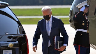 President Biden carries folders away from Marine One.