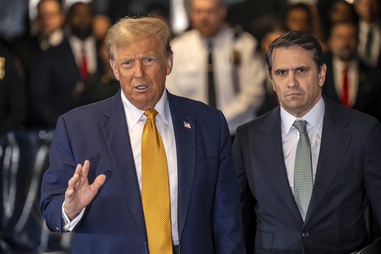 Donald Trump speaks while standing next to Todd Blanche