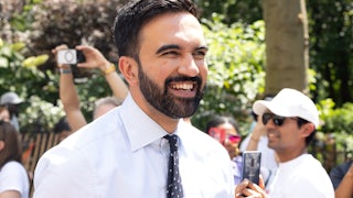 New York City mayoral candidate Zohran Mamdani is seen at the 2025 NYC Pride March on June 29, 2025 in New York, New York. He is wearing a white button-up shirt and a spotted black tie and smiling.