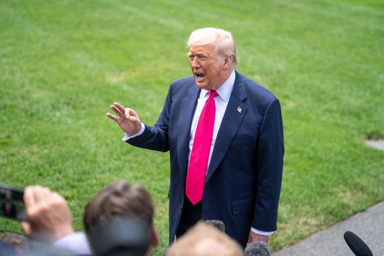 Donald Trump gestures while speaking to reporters outside the White House