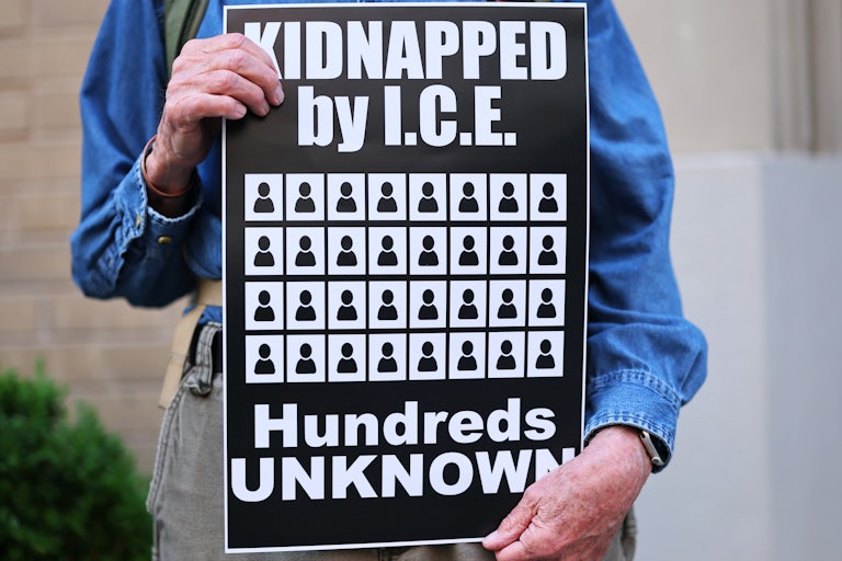 A person holds a sign that says, "Kidnapped by ICE. Hundreds unknown" at a rally protesting against Donald Trump's deportations