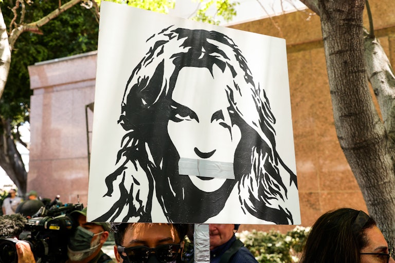 Activists supporting Britney Spears hold a sign aloft at a protest during the pop star's conservatorship hearing.
