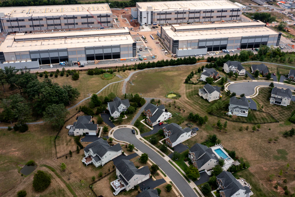 In an aerial view, an Amazon Web Services data center is shown situated near single-family homes in Stone Ridge, Virginia. Northern Virginia is the largest data center market in the world, according to a report this year cited in published accounts, but is facing headwinds from availability of land and electric power.