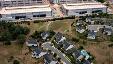In an aerial view, an Amazon Web Services data center is shown situated near single-family homes in Stone Ridge, Virginia. Northern Virginia is the largest data center market in the world, according to a report this year cited in published accounts, but is facing headwinds from availability of land and electric power.
