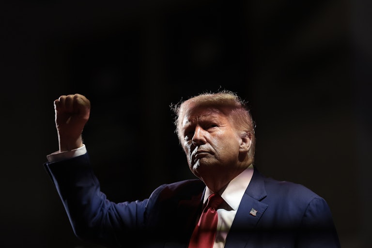 Donald Trump holds up his fist during a campaign event