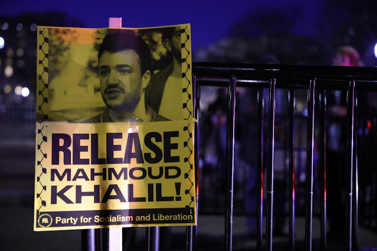 A protester holds up a sign that says, "Release Mahmoud Khalil" while standing outside the White House