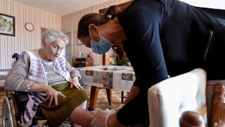 A nurse examines a woman's leg.
