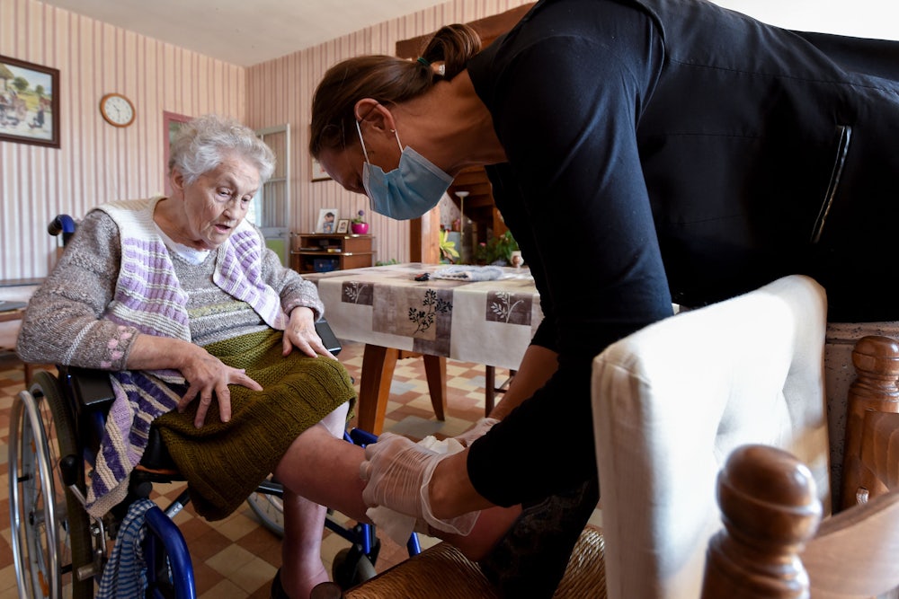 A nurse examines a woman's leg.