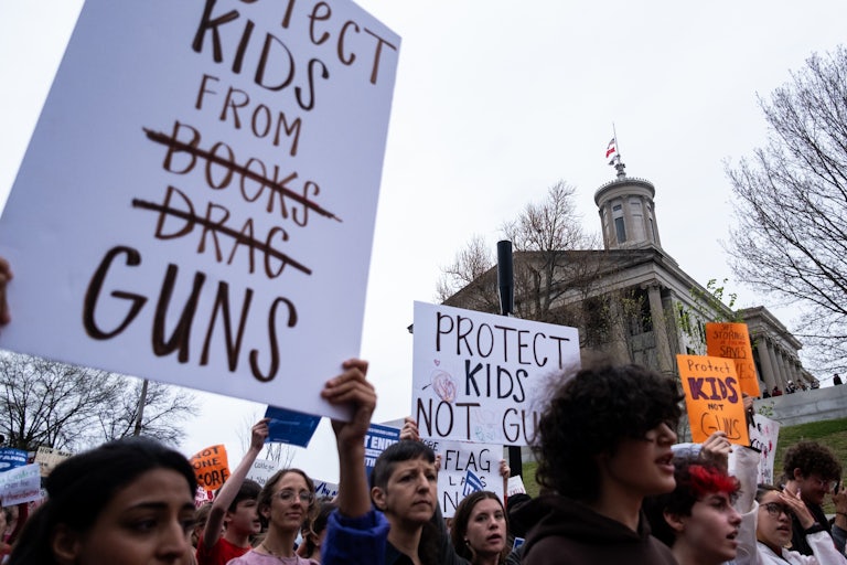 A sign reads "Protect Kids from Books Drag Guns" with Books and Drag crossed out.
