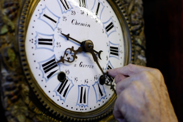 A man sets the clock back to mark the end of Daylight Saving Time.