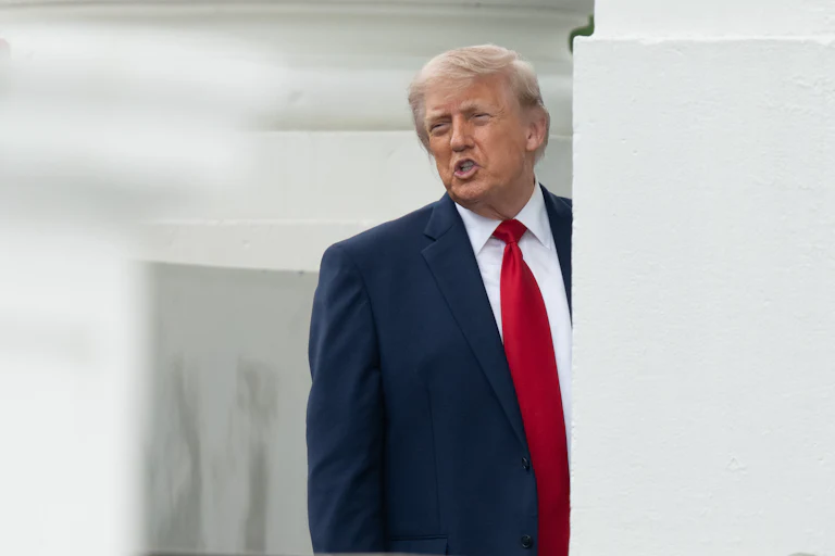 Donald Trump speaks while leaning out from behind a White House column