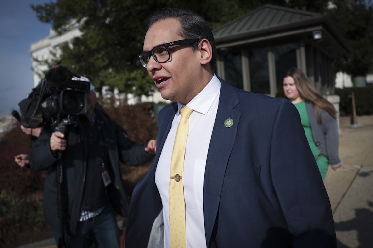 George Santos walks outside as reporters swarm him