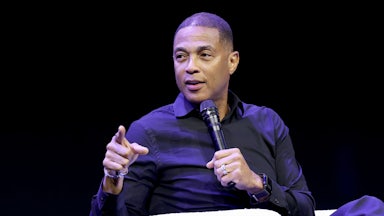Don Lemon points while speaking into a microphone