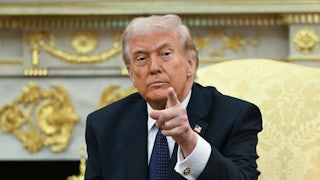 President Donald Trump points while sitting in the Oval Office of the White House.