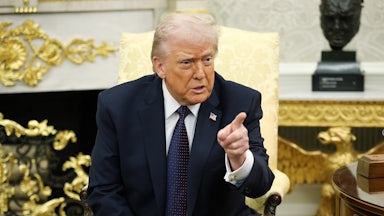 Donald Trump points while sitting the Oval Office of the White House.