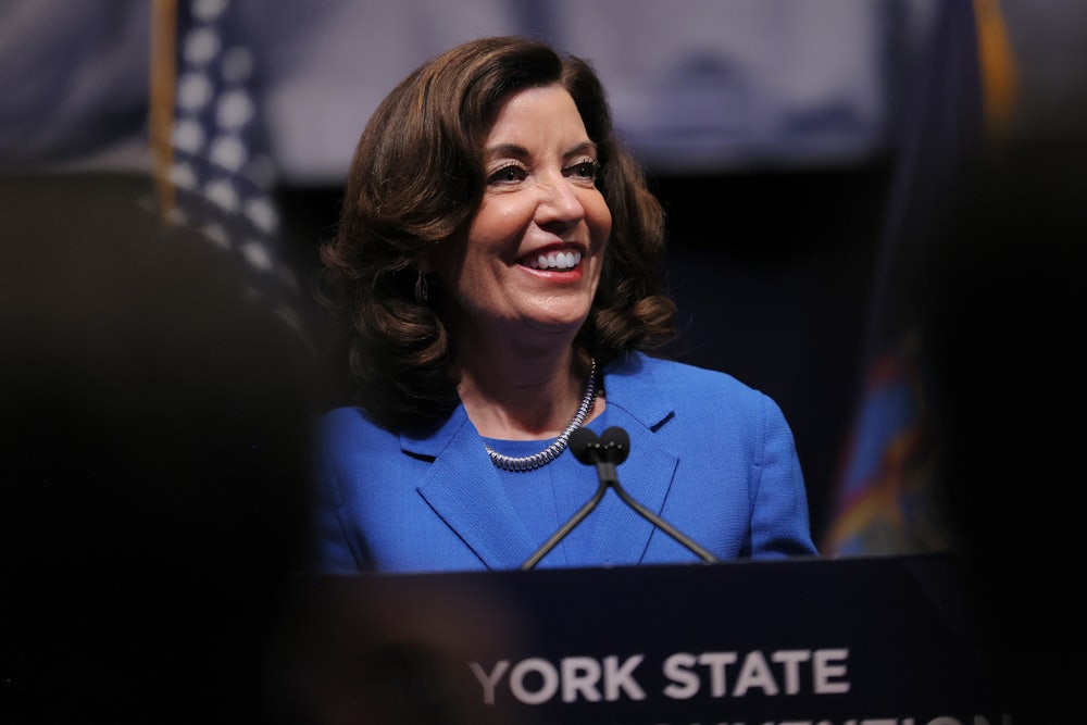 Kathy Hochul smiles while standing at a podium.