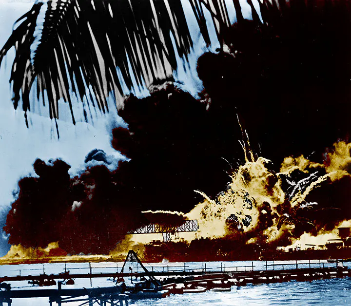 A colorized photograph of a boat exploding during the Japanese attack on Pearl Harbor