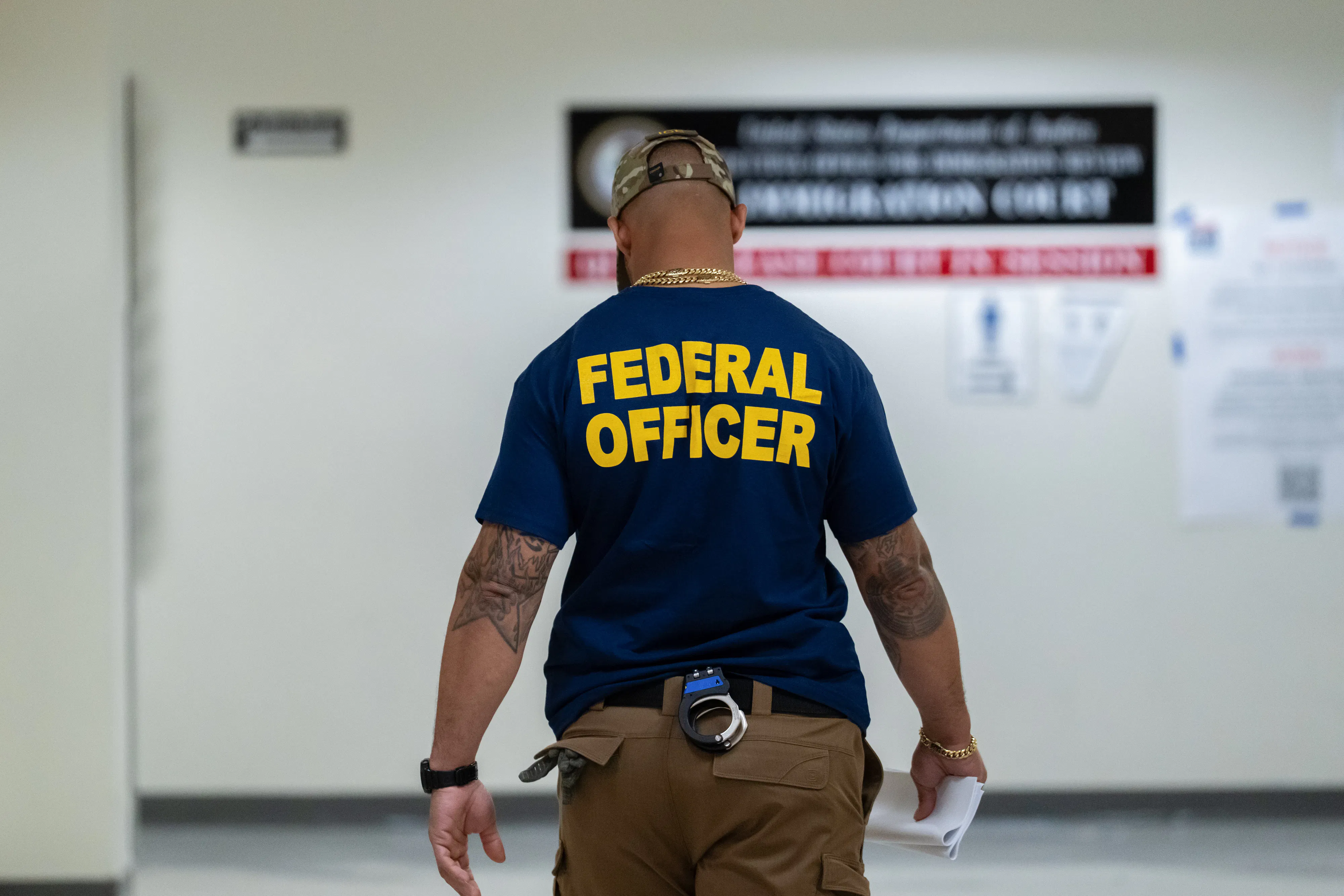Someone with a shirt that reads "Federal Officer"