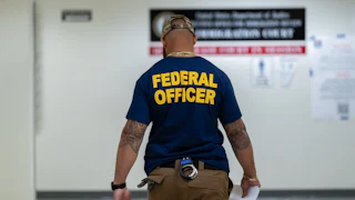 Someone with a shirt that reads "Federal Officer"