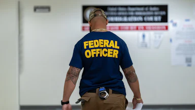 Someone with a shirt that reads "Federal Officer"