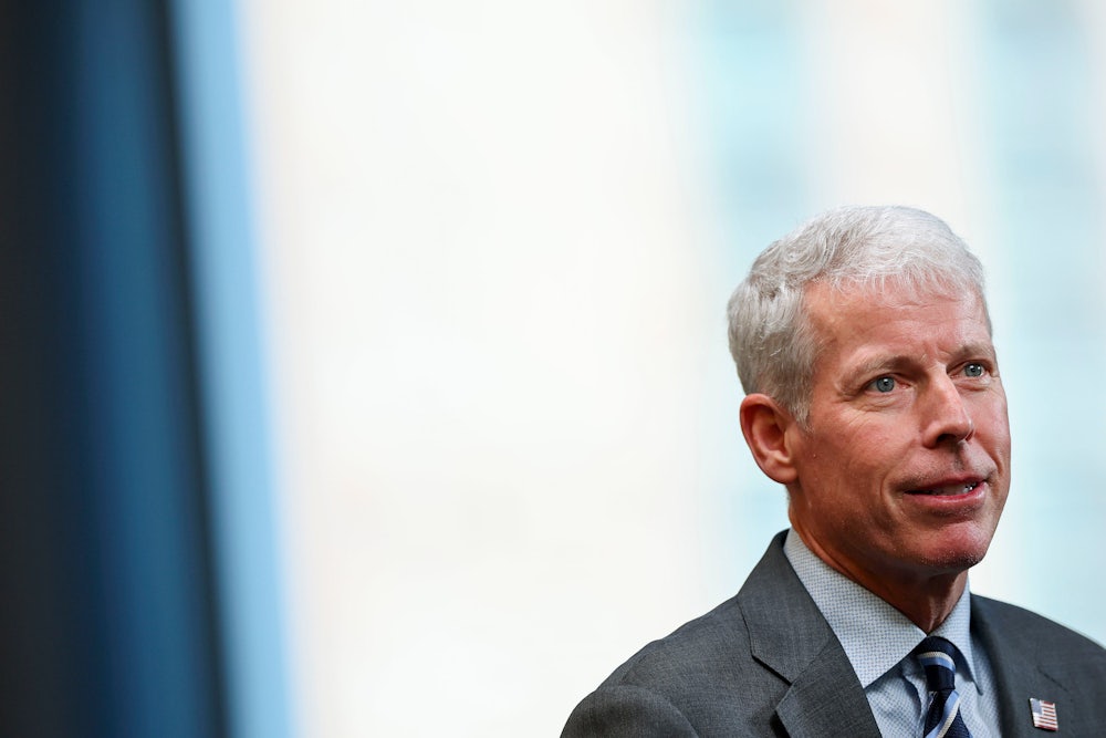 Chris Wright is seen from the shoulders up wearing a suit.