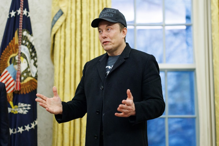 Elon Musk gestures while speaking during a press conference in the Oval Office