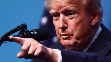 Donald Trump points while standing at a podium during a press conference at the NATO summit in Turkey