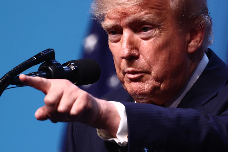 Donald Trump points while standing at a podium during a press conference at the NATO summit in Turkey