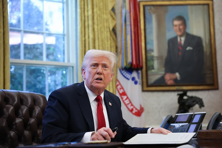 Donald Trump looks up while seated at his desk in the Oval Office
