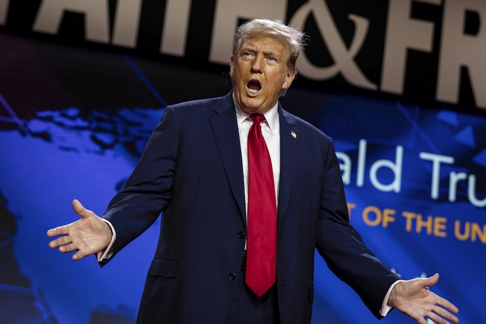 Donald Trump spreads his hands while speaking to an audience