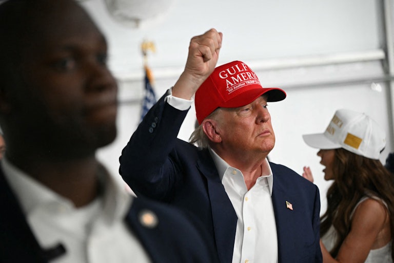 Donald Trump raises his fist above his head while visiting Alligator Alcatraz in Florida