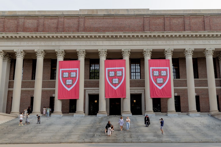 Harvard University building with three large Harvard banners hanging.