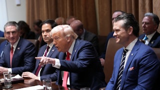 Donald Trump speaks and points a finger while at his Cabinet meeting. Marco Rubio sits to his right, looking stern, and Pete Hegseth sits to his left, smiling.