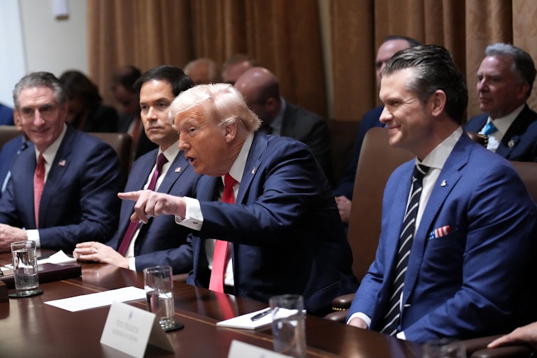 Donald Trump speaks and points a finger while at his Cabinet meeting. Marco Rubio sits to his right, looking stern, and Pete Hegseth sits to his left, smiling.