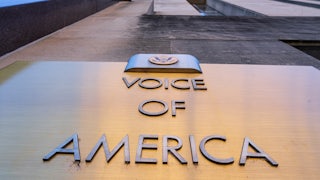 The Voice of America plaque on the side of the building