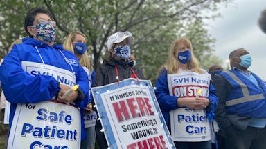 Nurses wear protest signs and hold candles during a strike vigil at Saint Vincent Hospital in Worcester, Massachusetts.