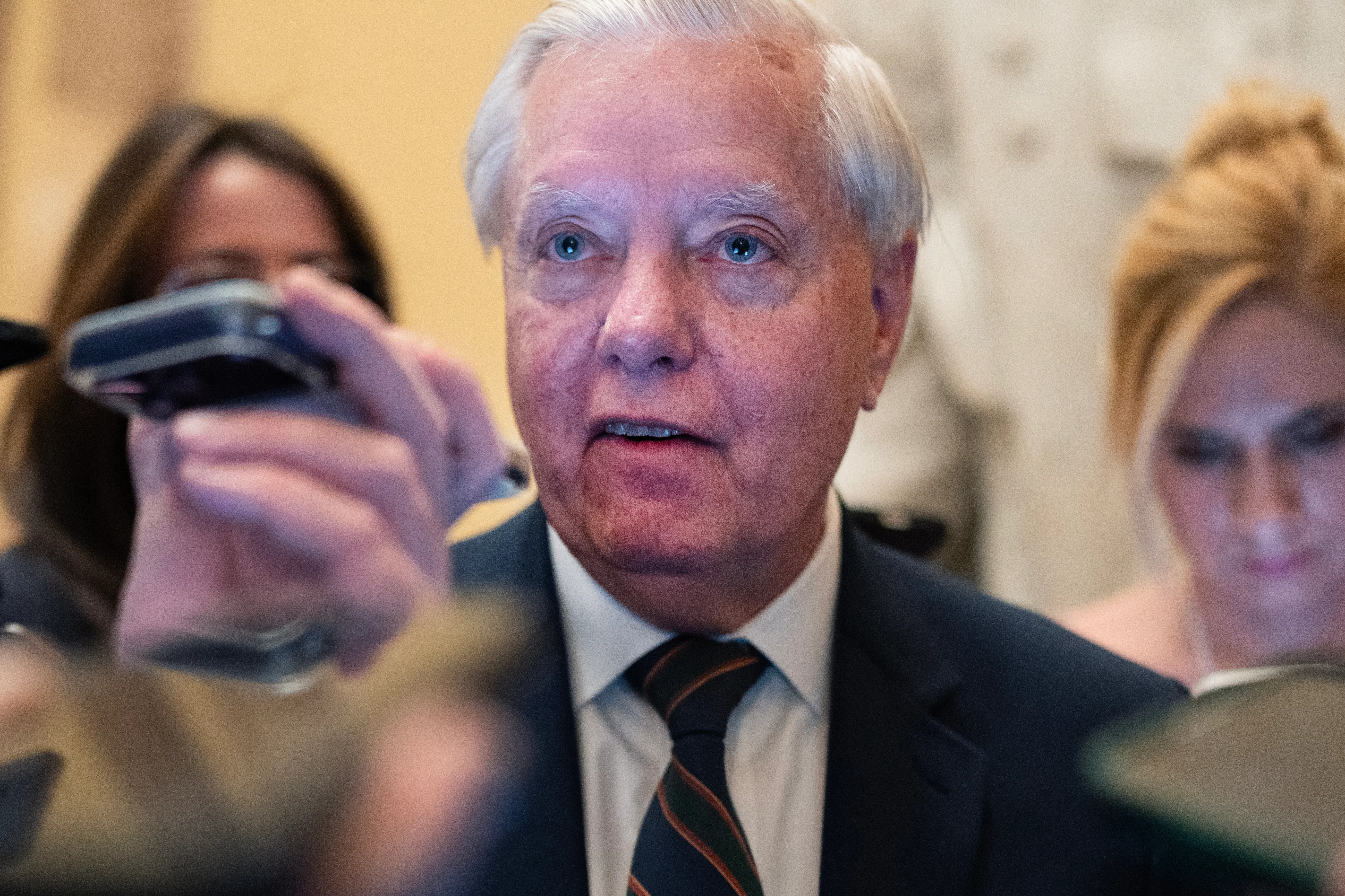 Senator Lindsey Graham stands in a crowd of reporters in the U.S. Capitol