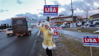 Darlene Heckler, an Inupiaq Native American, greets motorists while supporting U.S. Senator Lisa Murkowski for reelection in Anchorage, Alaska.