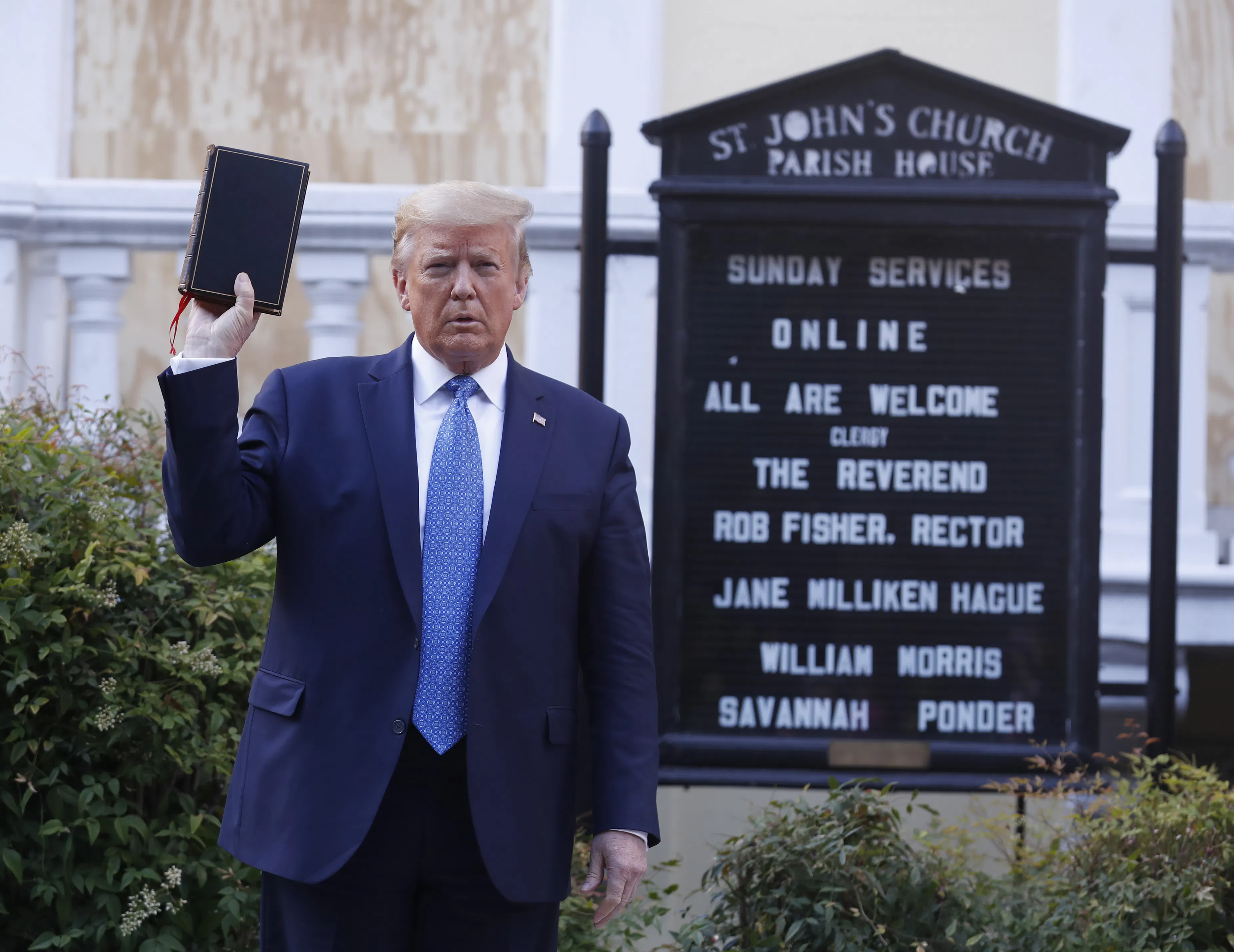 President Donald Trump holds up in his right hand as he stands in front of St. John’s Episcopal Church.