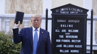 President Donald Trump holds up in his right hand as he stands in front of St. John’s Episcopal Church.