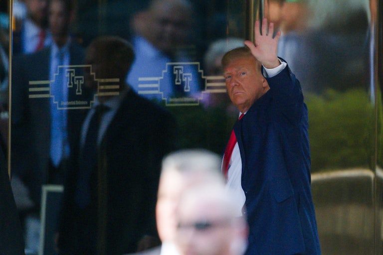Donald Trump waves as he enters a building.