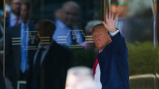 Donald Trump waves as he enters a building.